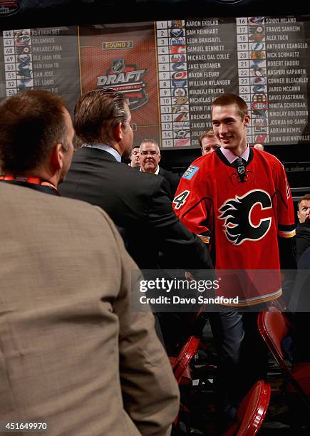 Mason McDonald greets his team after being selected 34th overall by the Calgary Flames during the 2014 NHL Entry Draft at Wells Fargo Center on June...