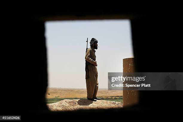 Soldier with the Kurdish peshmerga pauses at an outpost on the edges of the contested city of Kirkuk on July 3, 2014 in Kirkuk, Iraq. On Thursday the...