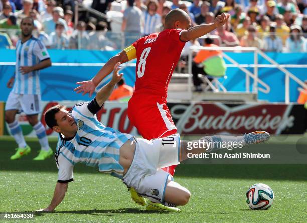 Lionel Messi of Argentina and Gokhan Inler of Switzerland compete for the ball during the 2014 FIFA World Cup Brazil Round of 16 match between...