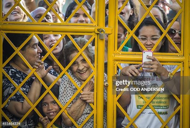 Brazilian football fans crowd outside the gate as their national team arrives for a training session at the President Vargas stadium on the eve of...