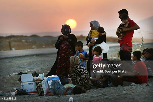 Iraqi family who fled recent fighting near the city of Mosul prepares to sleep on the ground as they try to enter a temporary displacement camp but...