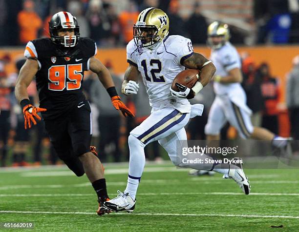 Running back Dwayne Washington of the Washington Huskies heads for the end zone and a touchdown as defensive end Scott Crichton of the Oregon State...