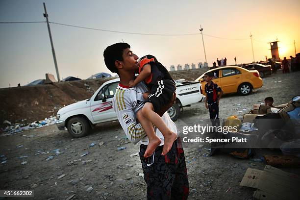 Iraqi families who fled recent fighting near the city of Mosul prepare to sleep on the ground as they try to enter a temporary displacement camp but...