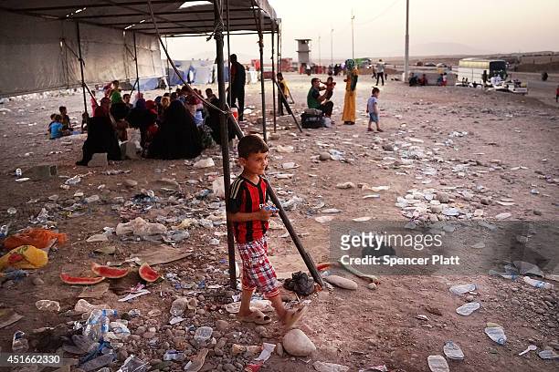 Iraqi families who fled recent fighting near the city of Mosul prepare to sleep on the ground as they try to enter a temporary displacement camp but...