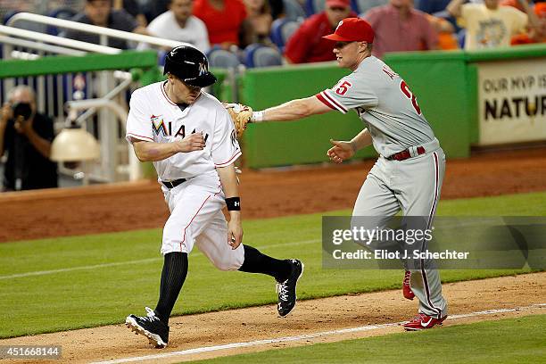 Jeff Baker of the Miami Marlins is tagged out in a rundown by Cody Asche of the Philadelphia Phillies in the eighth inning at Marlins Park on July 3,...