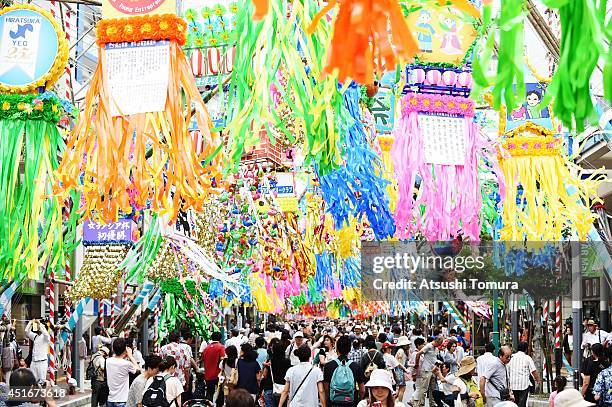 People walk under the colorful ornaments of Tanabata during the Shonan Hiratsuka Tanabata Festival on July 4, 2014 in Hiratsuka, Japan. Tanabata is a...