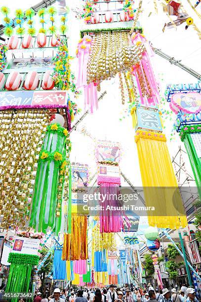 People walk under the colorful ornaments of Tanabata during the Shonan Hiratsuka Tanabata Festival on July 4, 2014 in Hiratsuka, Japan. Tanabata is a...