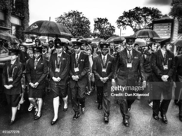 Security walk members of the public into the grounds as the gates are opened during the Wimbledon Championships at the 'All England Lawn Tennis and...