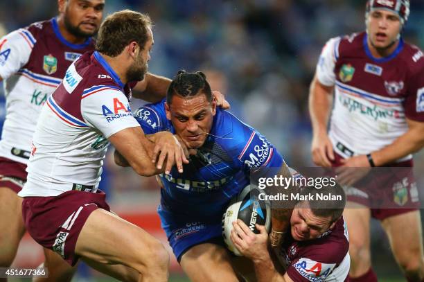 Reni Maitua of the Bulldogs is tackled during the round 17 NRL match between the Canterbury Bulldogs and the Manly Sea Eagles at ANZ Stadium on July...