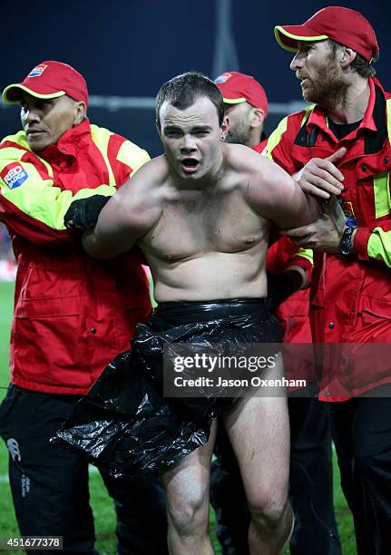 Streaker is removed by security staff during the round 18 Super Rugby match between the Chiefs and the Hurricanes at Waikato Stadium on July 4, 2014...