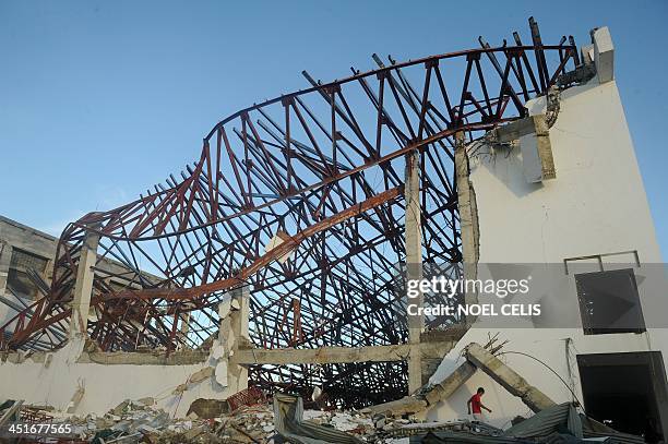 Man walks among debris of the destroyed Palo Convention Center in Palo, Leyte province, central Philippines, in November 24, 2013. Experts say it...
