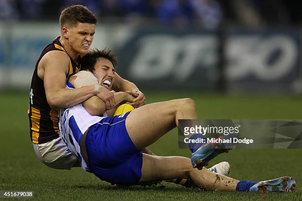 Taylor Duryea of the Hawks tackles Sam Wright of the Kangaroos the round 16 AFL match between North Melbourne Kangaroos and the Hawthorn Hawks at...