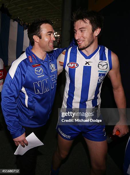 Kangaroos coach Brad Scott and Sam Wright of the Kangaroos celebrate their win during the round 16 AFL match between North Melbourne Kangaroos and...