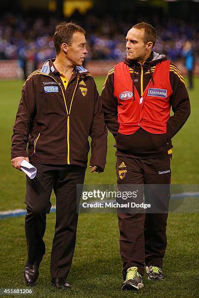 Hawks coach Alastair Clarkson walks off with Brad Sewell of the Hawks after their defeat during the round 16 AFL match between North Melbourne...