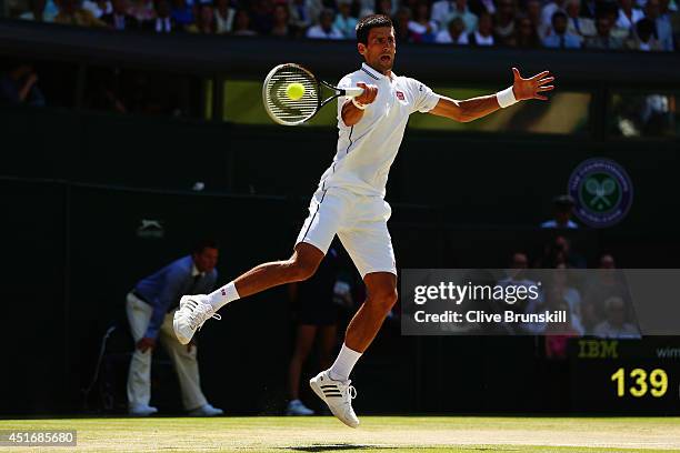 Novak Djokovic of Serbia jumps to make a return during his Gentlemen's Singles semi-final match against Grigor Dimitrov of Bulgaria on day eleven of...