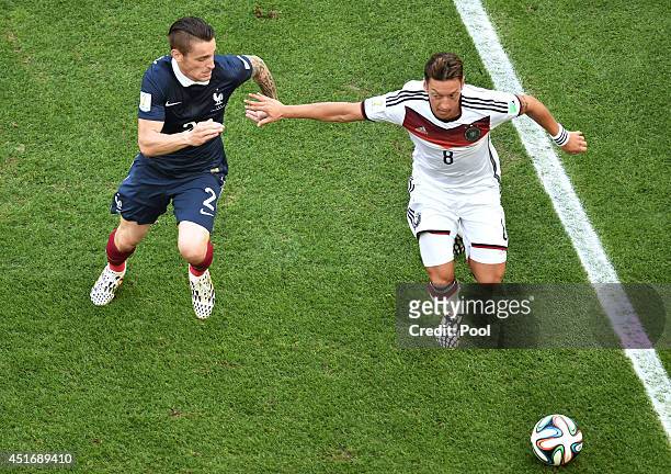 Mathieu Debuchy of France challenges Mesut Oezil of Germany during the 2014 FIFA World Cup Brazil Quarter Final match between France and Germany at...