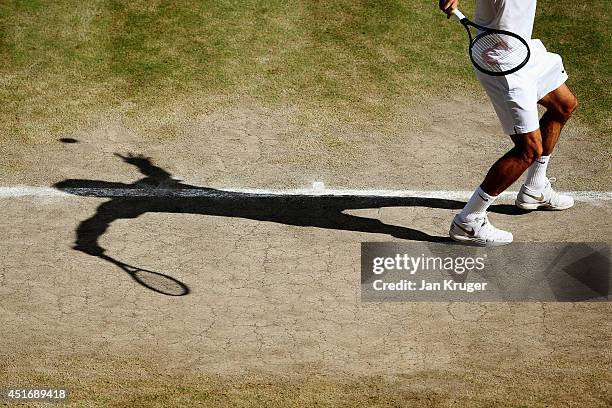 Detail shot of the shadow of Roger Federer of Switzerland as he serves during his Gentlemen's Singles semi-final match against Milos Raonic of Canada...