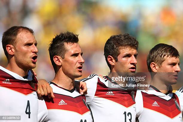 Benedikt Hoewedes, Miroslav Klose, Thomas Mueller and Toni Kroos of Germany sing the National Anthem prior to the 2014 FIFA World Cup Brazil Quarter...