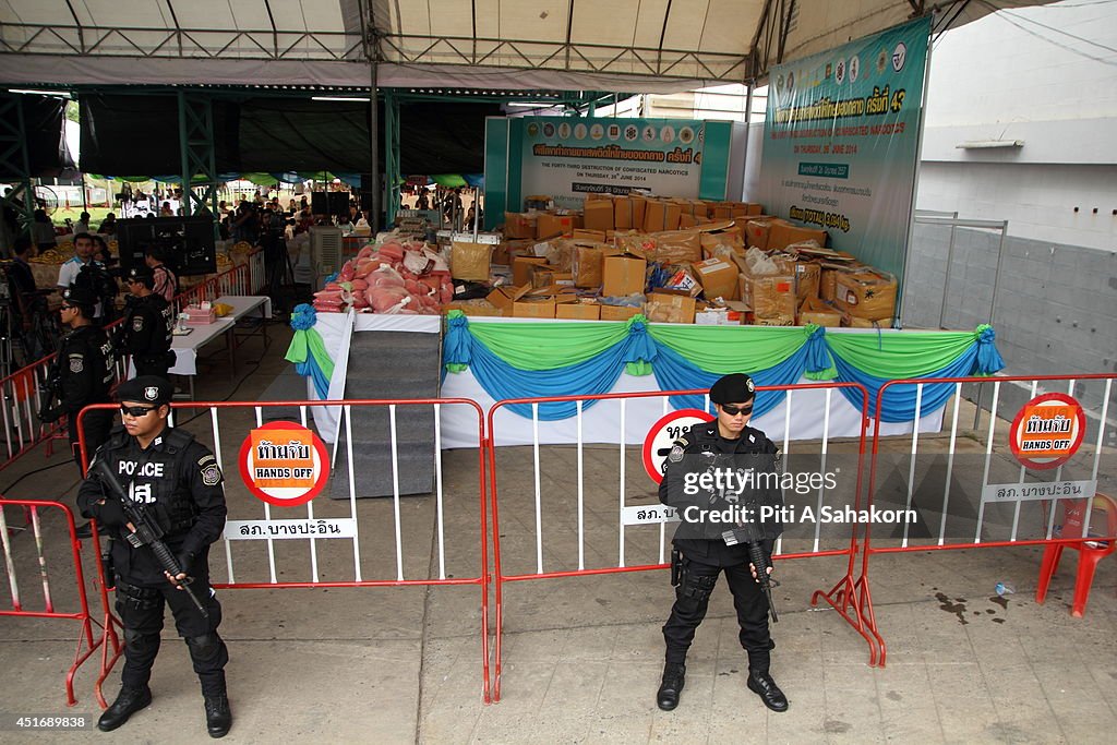 Thai police officers stand in front of methamphetamines...