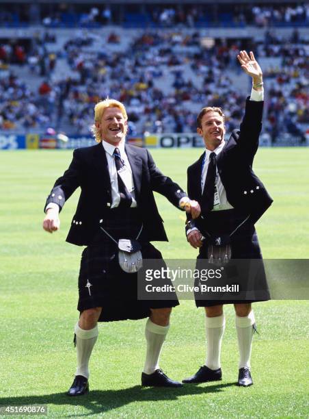 Scotland players Colin Hendry and Kevin Gallacher wave to fans whilst wearing their kilts before the opening FIFA 1998 World Cup match between Brazil...