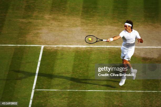 Roger Federer of Switzerland jumps as he makes a forehand return during his Gentlemen's Singles semi-final match against Milos Raonic of Canada on...