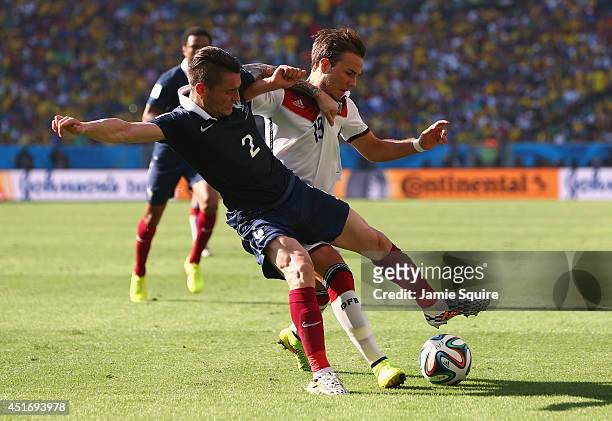 Mathieu Debuchy of France and Mario Goetze of Germany compete for the ball during the 2014 FIFA World Cup Brazil Quarter Final match between France...