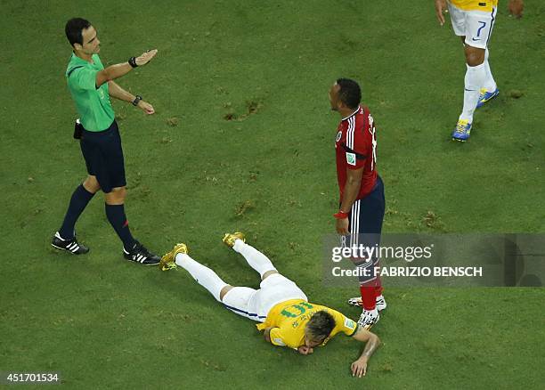 Spanish referee Carlos Velasco Carballo rewards a free kick to Brazil after Colombia's defender Juan Camilo Zuniga fouled Brazil's forward Neymar...