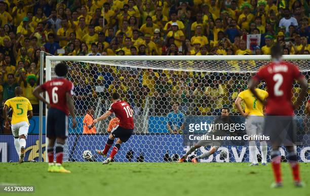James Rodriguez of Colombia shoots and scores his team's first goal on a penalty kick past Julio Cesar of Brazil during the 2014 FIFA World Cup...