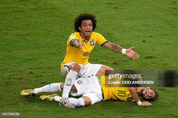 Brazil's defender Marcelo reacts over Brazil's forward Neymar after he was injured following a tackle during the quarter-final football match between...