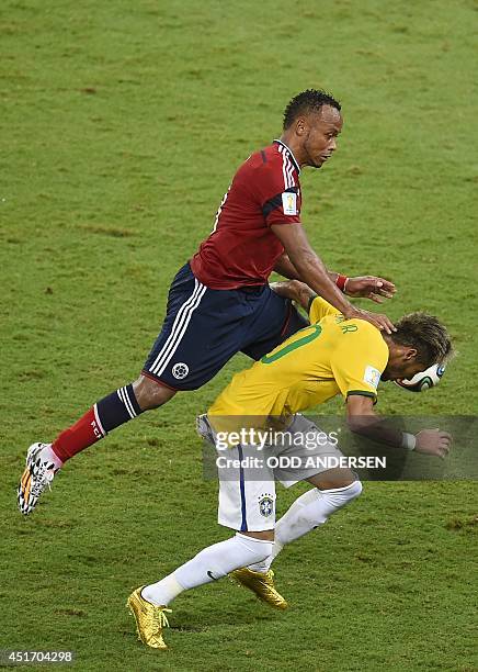 Colombia's defender Juan Camilo Zuniga fouls Brazil's forward Neymar during the quarter-final football match between Brazil and Colombia at the...