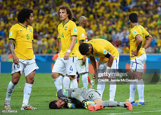 Goalkeeper Julio Cesar lies on the pitch after a clash as Thiago Silva of Brazil stands over during the 2014 FIFA World Cup Brazil Quarter Final...