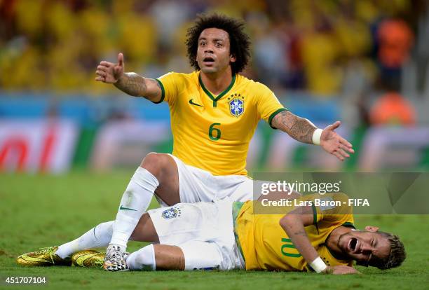 Neymar of Brazil lies injured while Marcelo of Brazil appeals during the 2014 FIFA World Cup Brazil Quarter Final match between Brazil and Colombia...