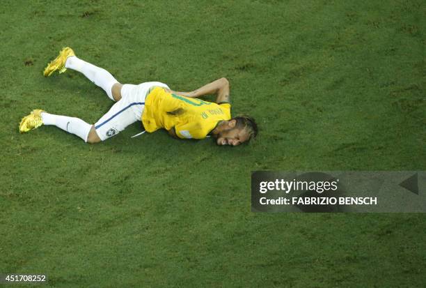 Brazil's forward Neymar reacts on the ground after being injured following a foul by Colombia's defender Juan Camilo Zuniga during the quarter-final...