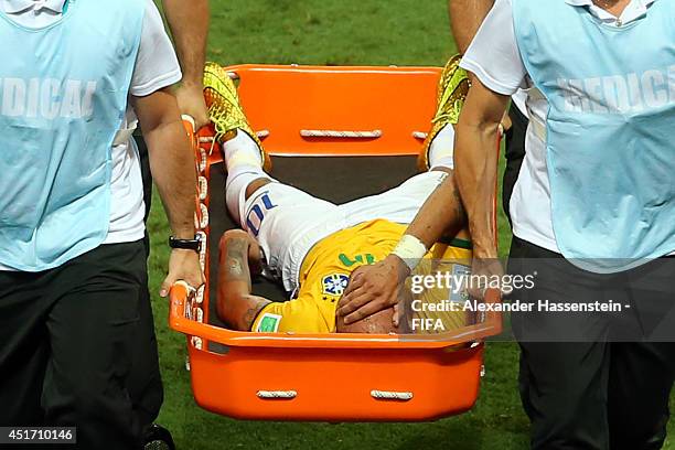 Neymar of Brazil is taken off the pitch by a stretcher during the 2014 FIFA World Cup Brazil Quarter Final match between Brazil and Colombia at...