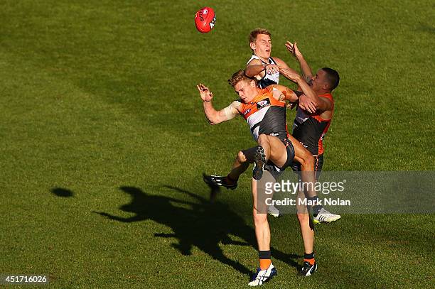 Adam Kennedy and Tom Scully of the Giants and David Mackay of the Crows contest a mark during the round 16 AFL match between the Greater Western...