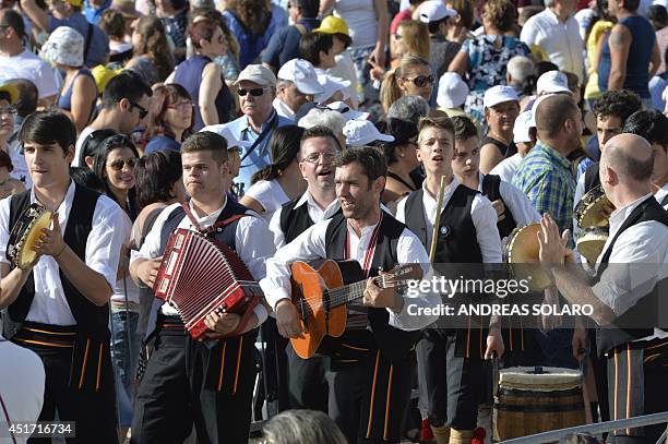 People perform traditional music before the arrival of Pope Francis in Campobasso, southern Italy, where he will preside a holy mass on July 5, 2014....