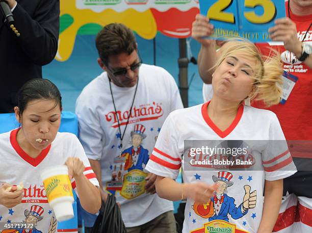 Sonya Thomas and Miki Sudo competes in the Women's Division at the 2014 Nathan's Famous 4th July International Hot Dog Eating Contest at Coney Island...