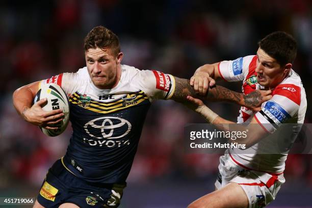 Tariq Sims of the Cowboys puts a fend on Gareth Widdop of the Dragons during the round 17 NRL match between the St George Illawarra Dragons and the...