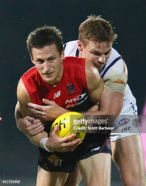 Jack Grimes of the Demons is tackled by Colin Sylvia of the Dockers during the round 16 AFL match between the Melbourne Demons and the Fremantle...