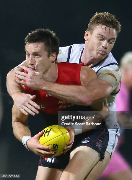 Jack Grimes of the Demons is tackled by Colin Sylvia of the Dockers during the round 16 AFL match between the Melbourne Demons and the Fremantle...