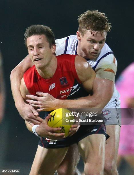 Jack Grimes of the Demons is tackled by Colin Sylvia of the Dockers during the round 16 AFL match between the Melbourne Demons and the Fremantle...