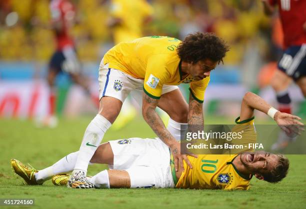 Neymar of Brazil lies injured while Marcelo of Brazil shows concern during the 2014 FIFA World Cup Brazil Quarter Final match between Brazil and...