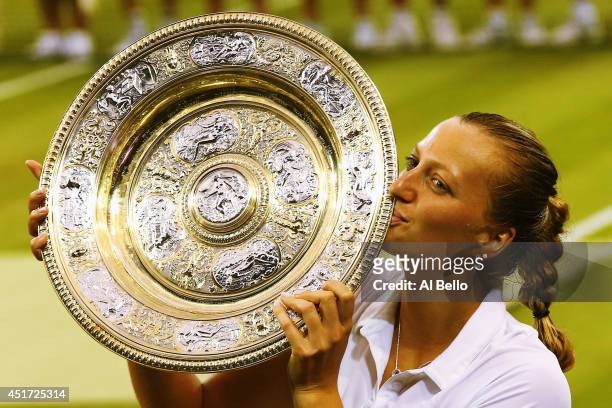 Petra Kvitova of Czech Republic poses with the Venus Rosewater Dish trophy after her victory in the Ladies' Singles final match against Eugenie...