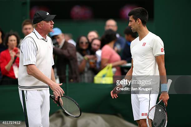 Novak Djokovic of Serbia talks with his coach Boris Becker during a practice session on day twelve of the Wimbledon Lawn Tennis Championships at the...