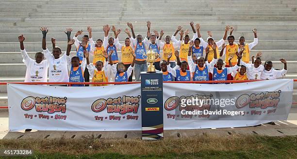 Children pose with the Webb Ellis Cup prior to the IRB Get Into Rugby tournament during a visit to Andohatapenaka Stadium during the Rugby World Cup...