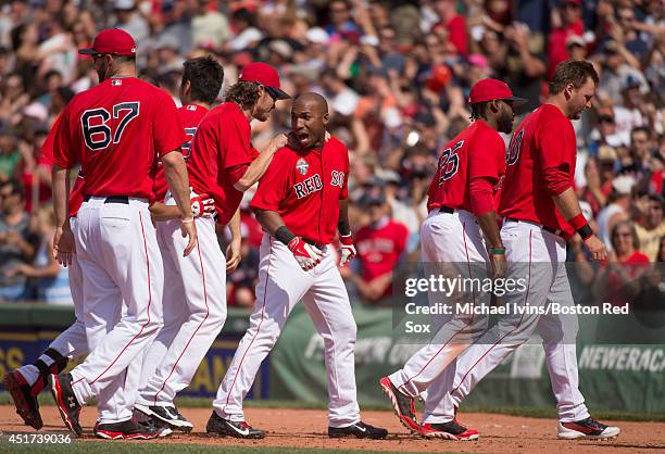 Jonathan Herrera of the Boston Red Sox is surrounded by teammates after hitting a walk-off single against the Baltimore Orioles in the ninth inning...