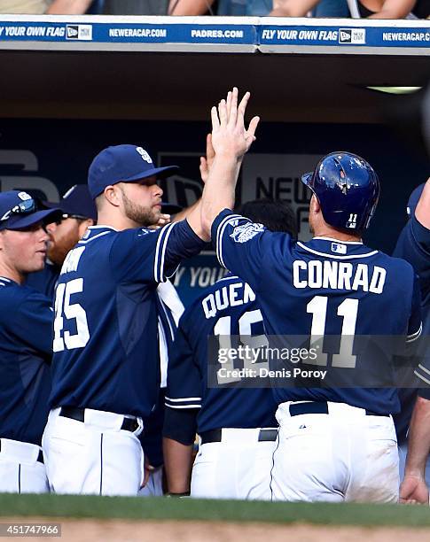 Brooks Conrad of the San Diego Padres, right, is congratulated after scoring during the sixth inning of a baseball game against the San Francisco...