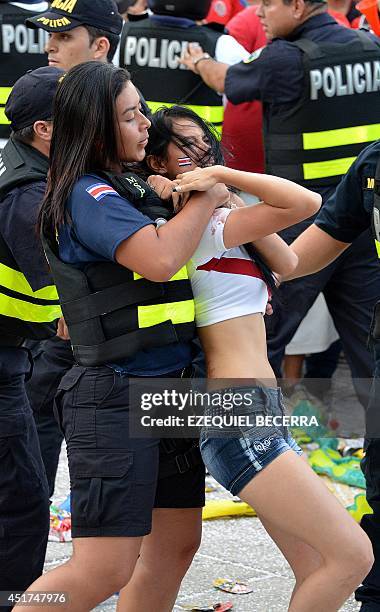 Policewoman arrests a Costa Rican fan after three men were stabbed while watching the Brazil 2014 FIFA World Cup football match against Netherlands...