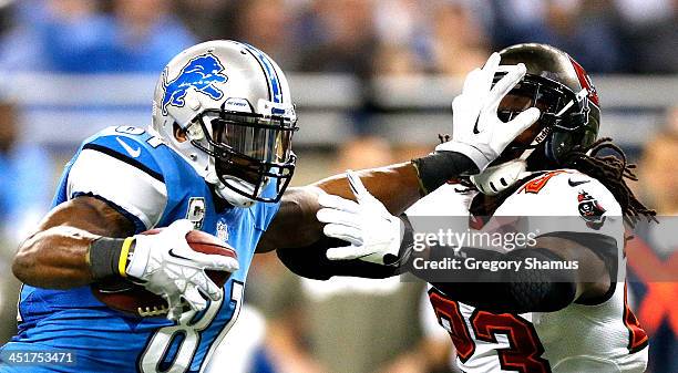 Calvin Johnson of the Detroit Lions stiff arms Mark Barron of the Tampa Bay Buccaneers in the second quarter at Ford Field on November 24, 2013 in...