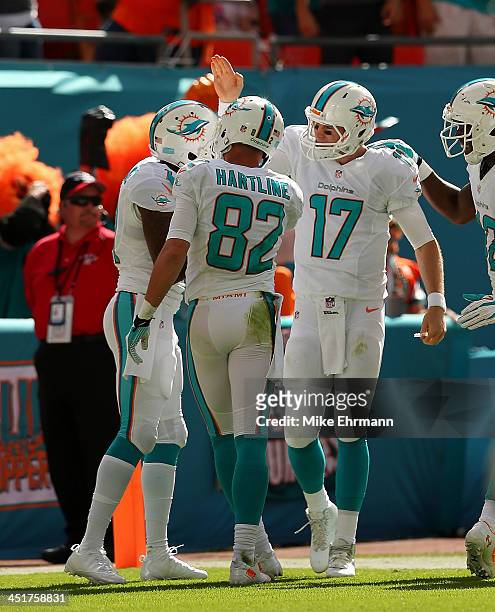 Ryan Tannehill of the Miami Dolphins congratulates Mike Wallace on a touchdown during a game against the Carolina Panthers at Sun Life Stadium on...